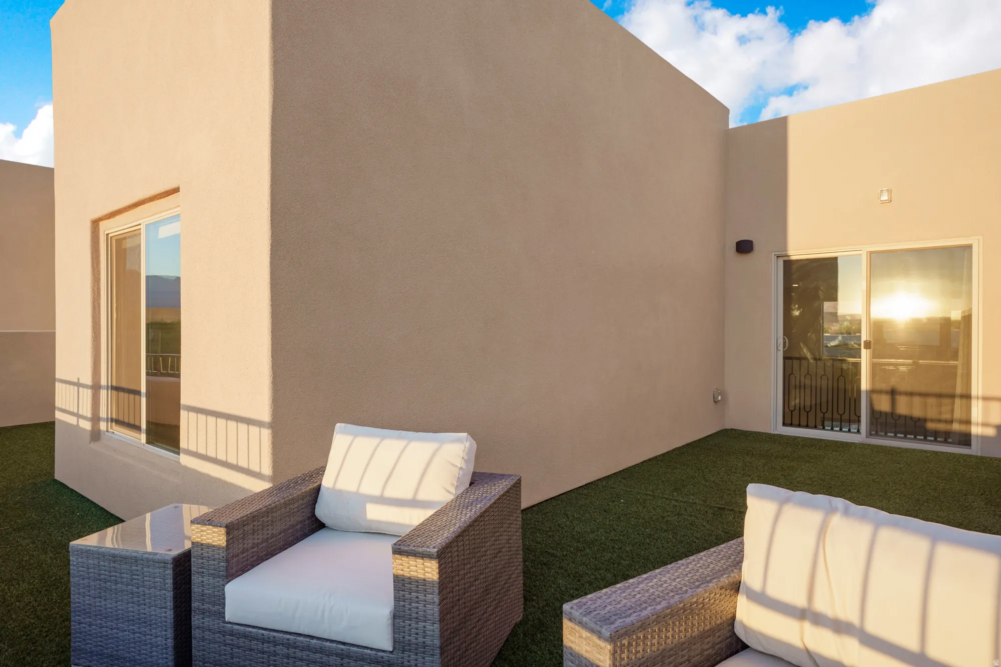 Rooftop terrace featuring artificial turf, sliding glass door access, and a perimeter safety railing