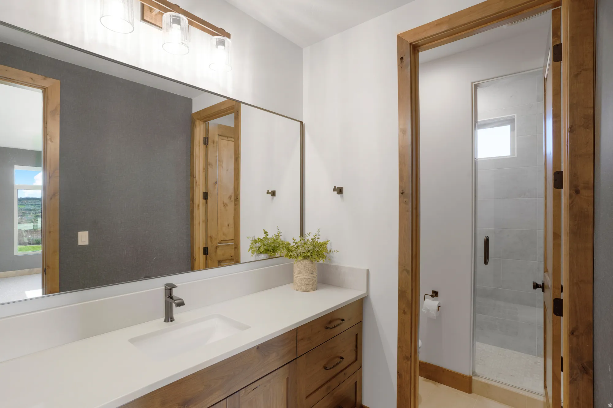Wood-finish vanity with white countertop and integrated rectangular sink