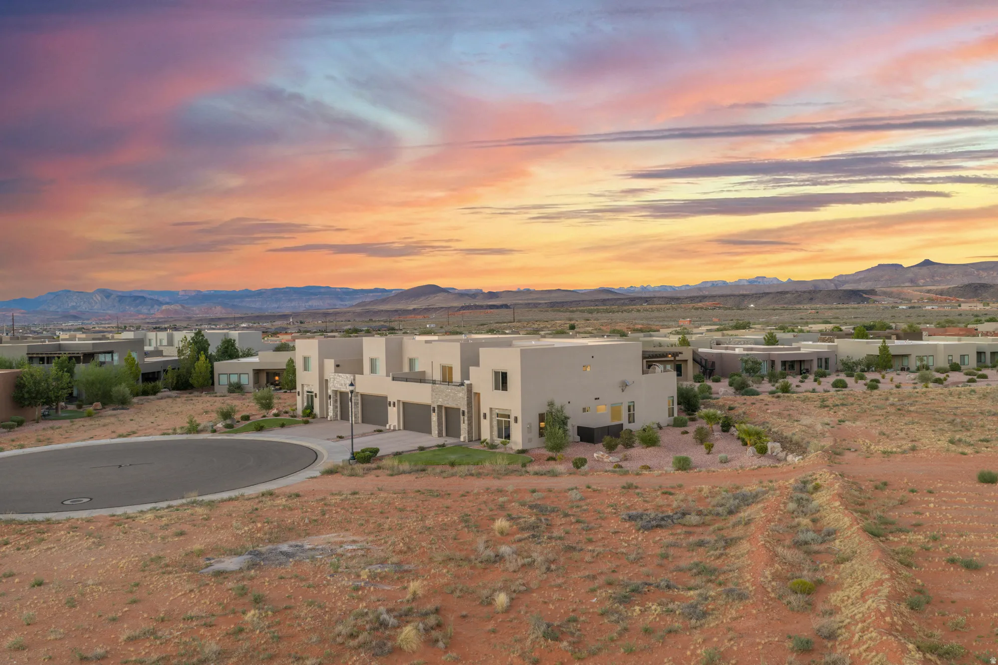 Modern desert architecture featuring stucco exterior finishes, integrated garage doors, and low-maintenance landscaping