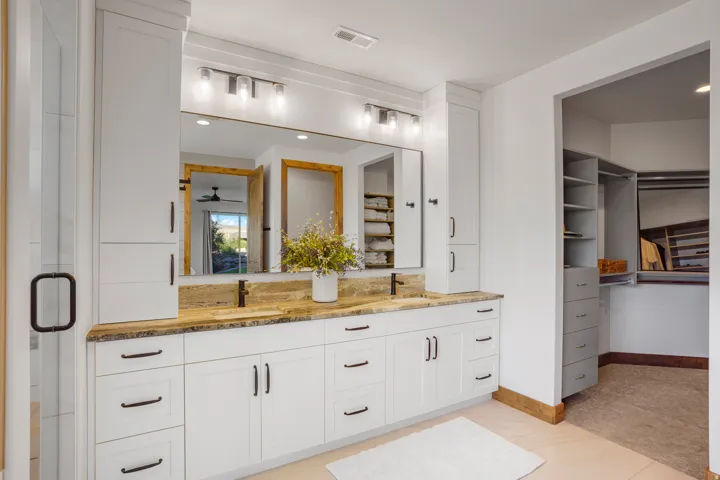 Dual vanity with white cabinetry and dark hardware