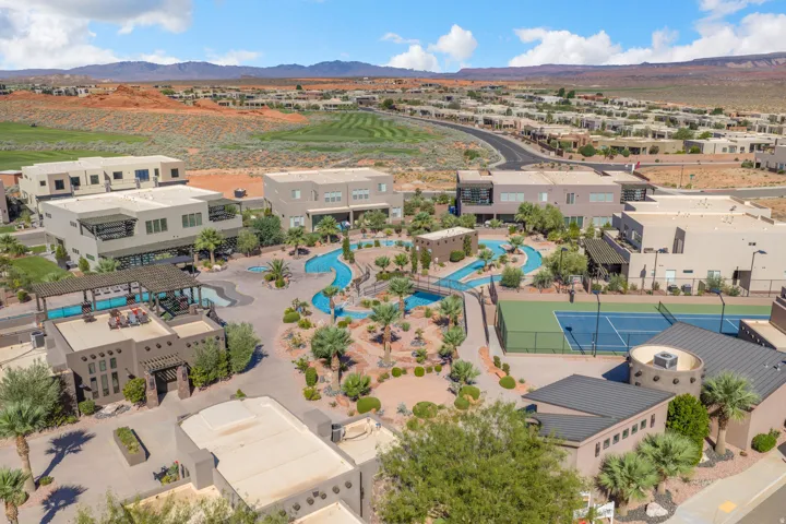 Community featuring multiple buildings, a tennis court, and a multi-level pool with a lazy river