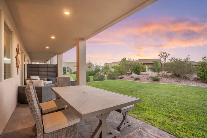 Expansive covered patio with recessed lighting, stamped concrete flooring, and direct access to a manicured lawn