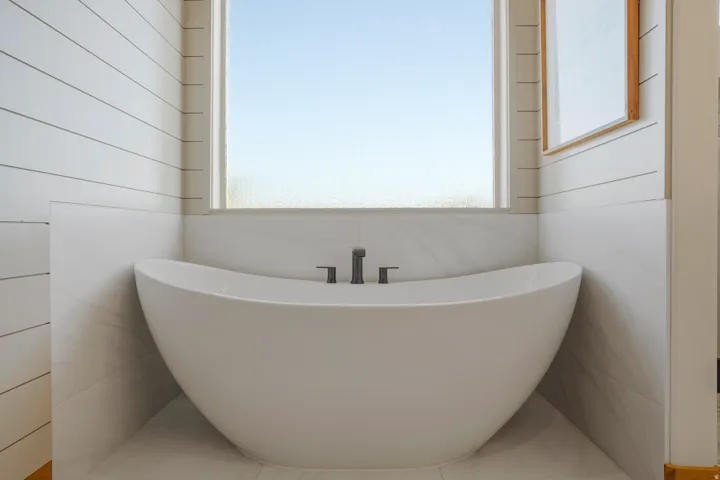Freestanding soaking tub with dark-toned fixtures