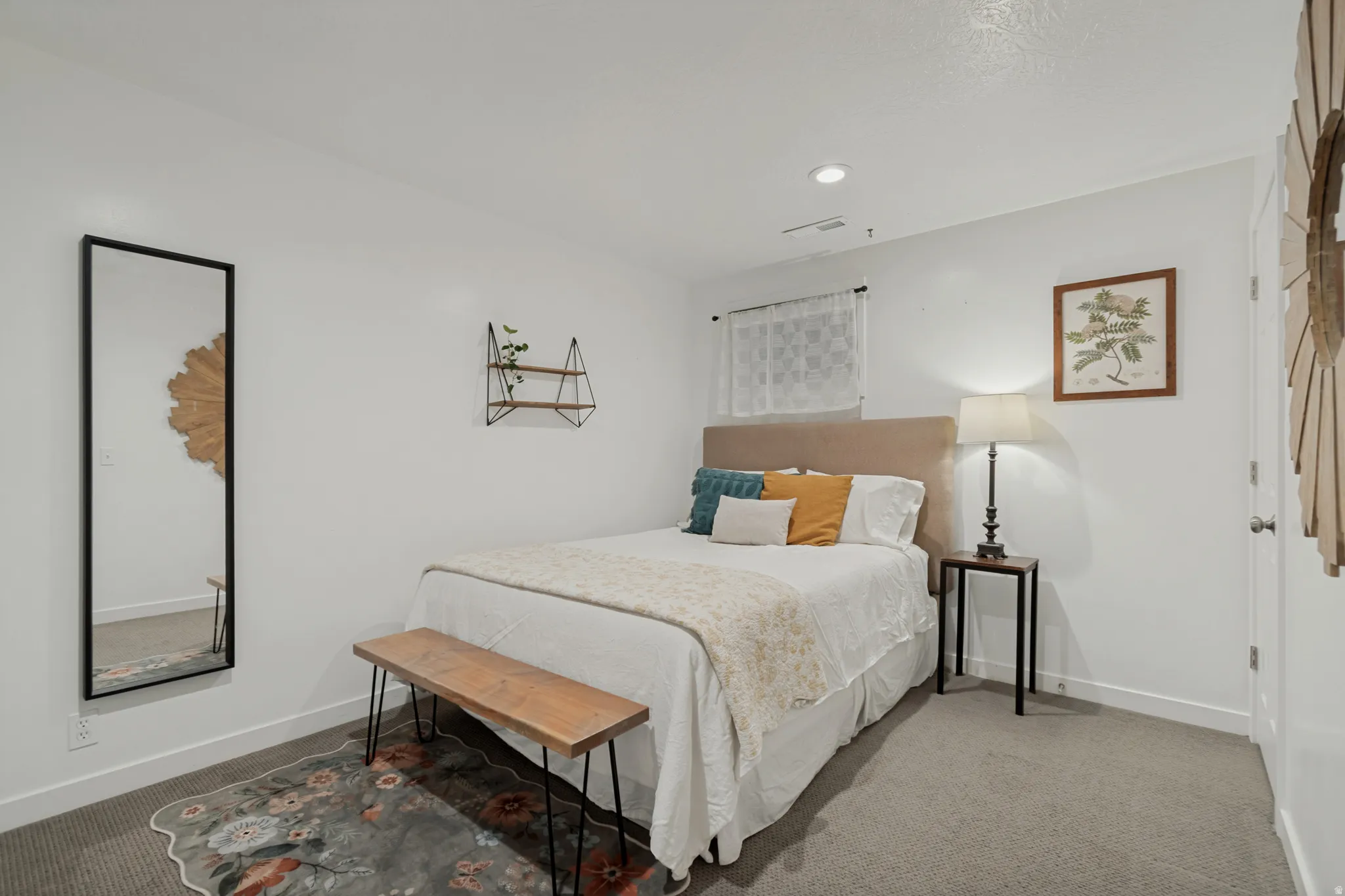 Plush carpet flooring, recessed ceiling lighting, and a window with a white sheer curtain
