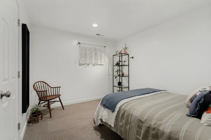 Recessed ceiling lighting, white interior door, window with natural light, carpeted flooring, and crisp white walls