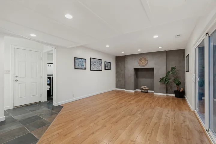 Recessed lighting, wood-finish flooring, fireplace feature wall, sliding glass door, and slate tile entry