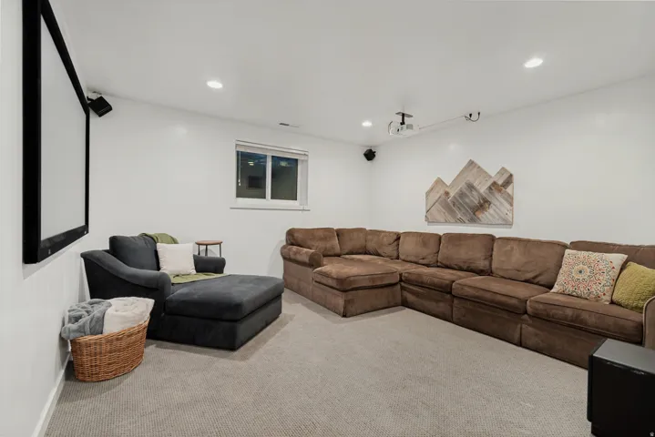 Recessed lighting, window with blinds, wall-mounted screen, ceiling-mounted projector, and wall-mounted speakers
