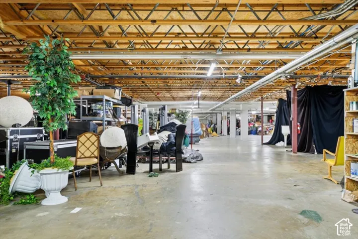 Exposed ceiling trusses, concrete flooring, and ample open space