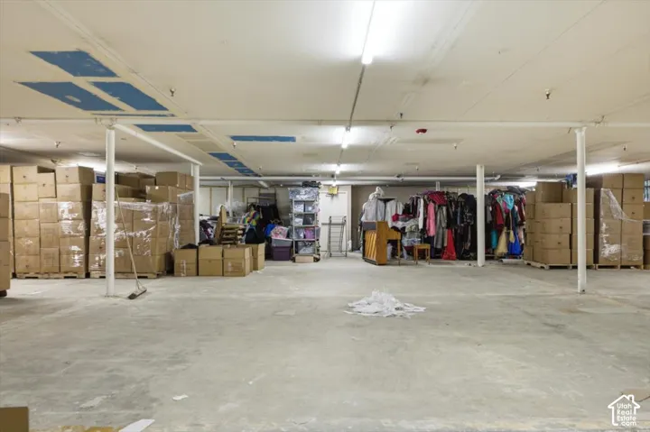 Concrete flooring with support columns and fluorescent lighting