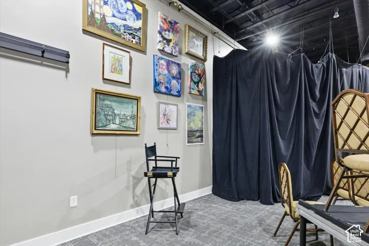 Light grey wall with white trim, dark ceiling, and grey patterned carpet