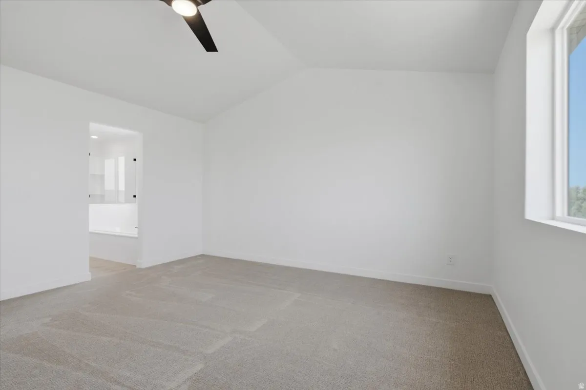 Primary Bedroom with vault and ceiling fan.