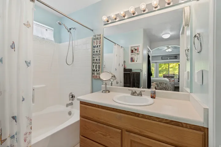 Bathroom featuring a vanity with an integrated sink, a large mirror, and overhead vanity lighting