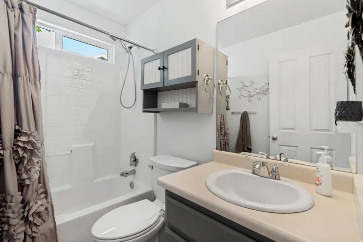 White tiled shower-tub combination with a chrome shower head and fixtures