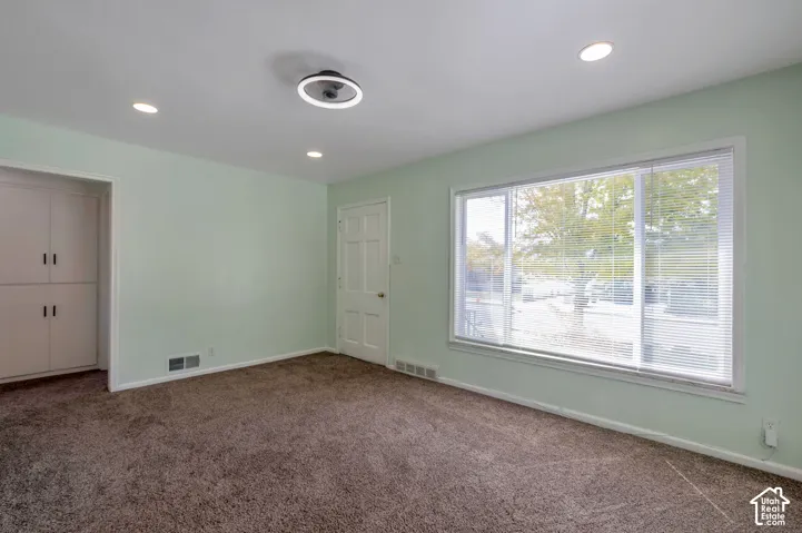 Recessed lighting, large window with blinds, panel door, built-in cabinetry, and a contemporary ceiling fixture