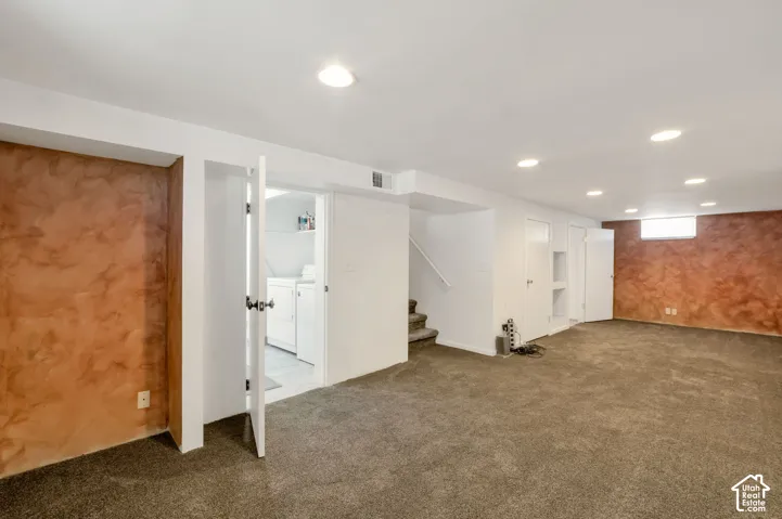 Huge!!! Expansive carpeted area with recessed lighting, textured accent walls, and a separate laundry area with built-in shelving