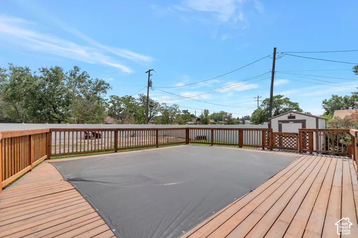 Expansive outdoor deck with natural wood finish, bordered by a substantial wooden railing