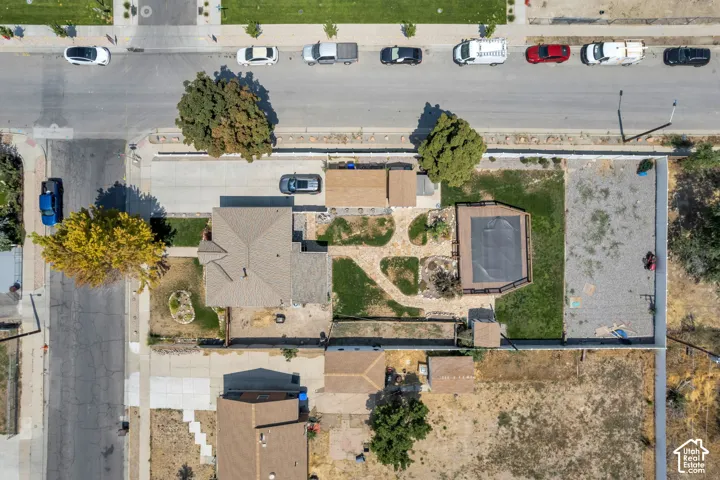 Gable roofline, rear deck with a covered pool, paved driveway, and established trees