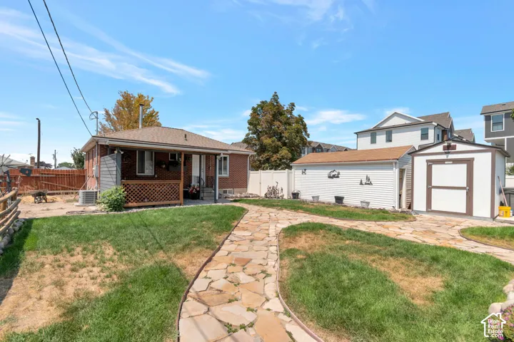Expansive yard with flagstone pathways, a detached garage, and an additional storage shed