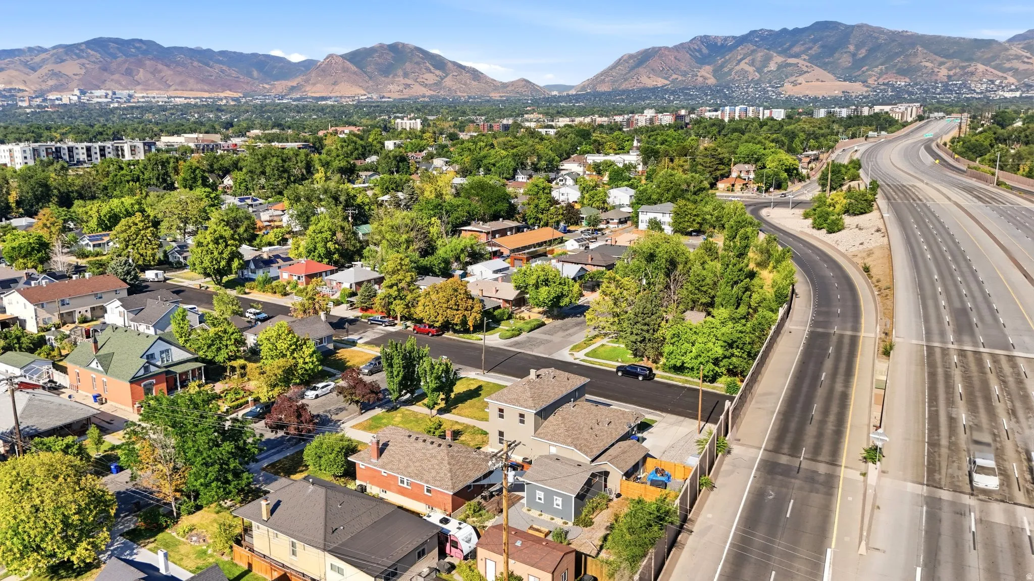 Residential neighborhood with established trees and mountain backdrop