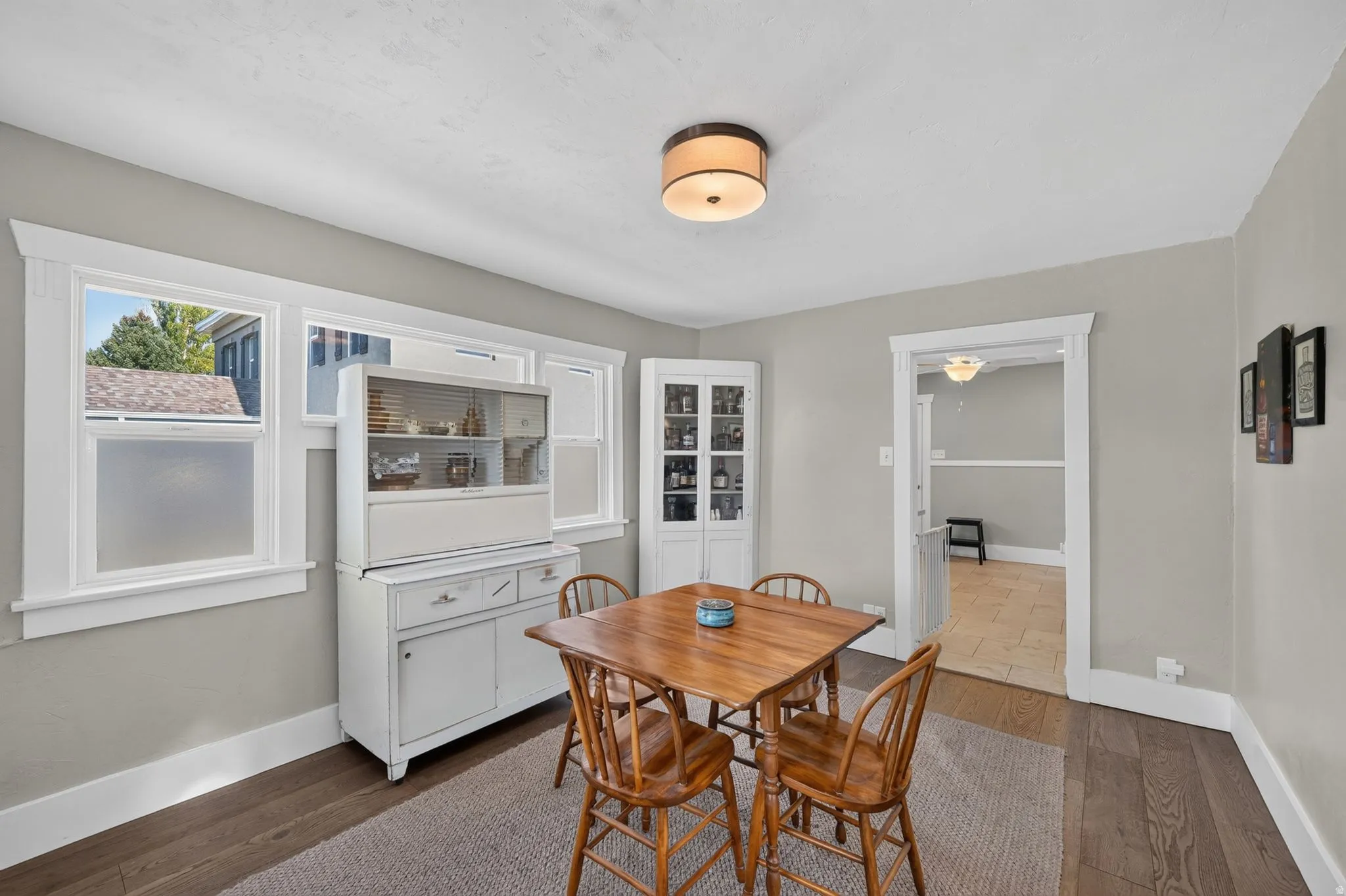 Wood-finish flooring with white trim and a neutral wall color
