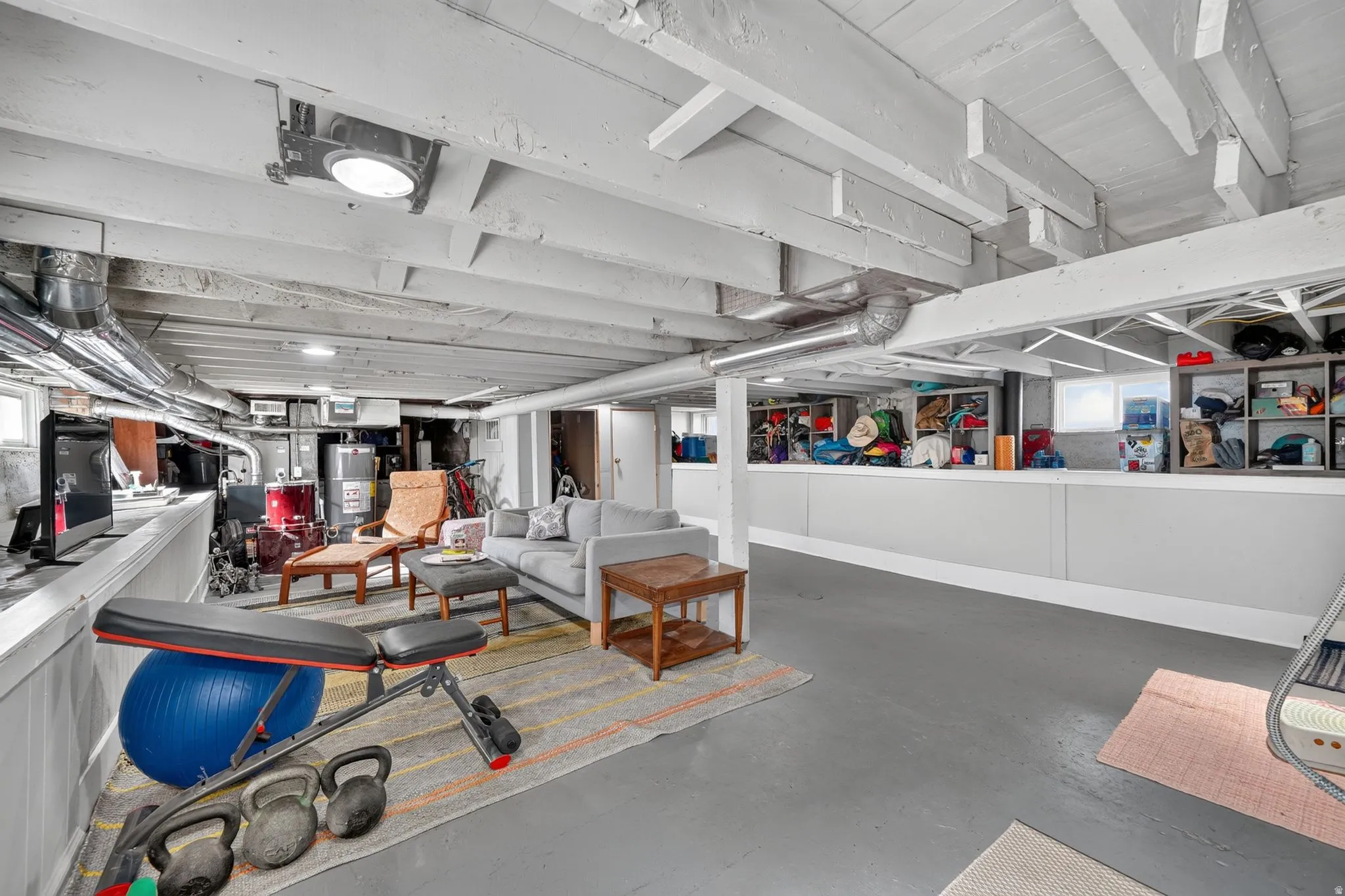 Expansive finished lower level featuring painted exposed ceiling beams, recessed lighting, and durable flooring
