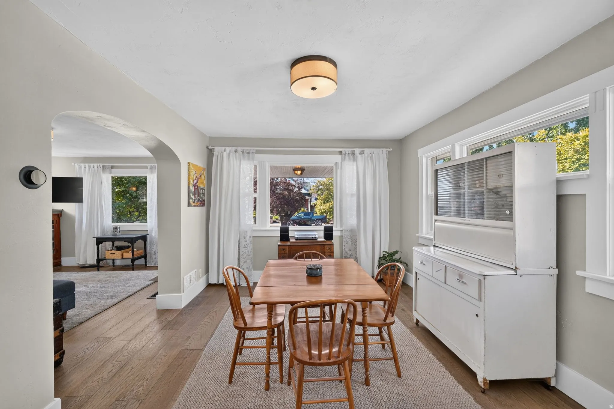 Hardwood-style flooring throughout, arched doorway, and built-in hutch