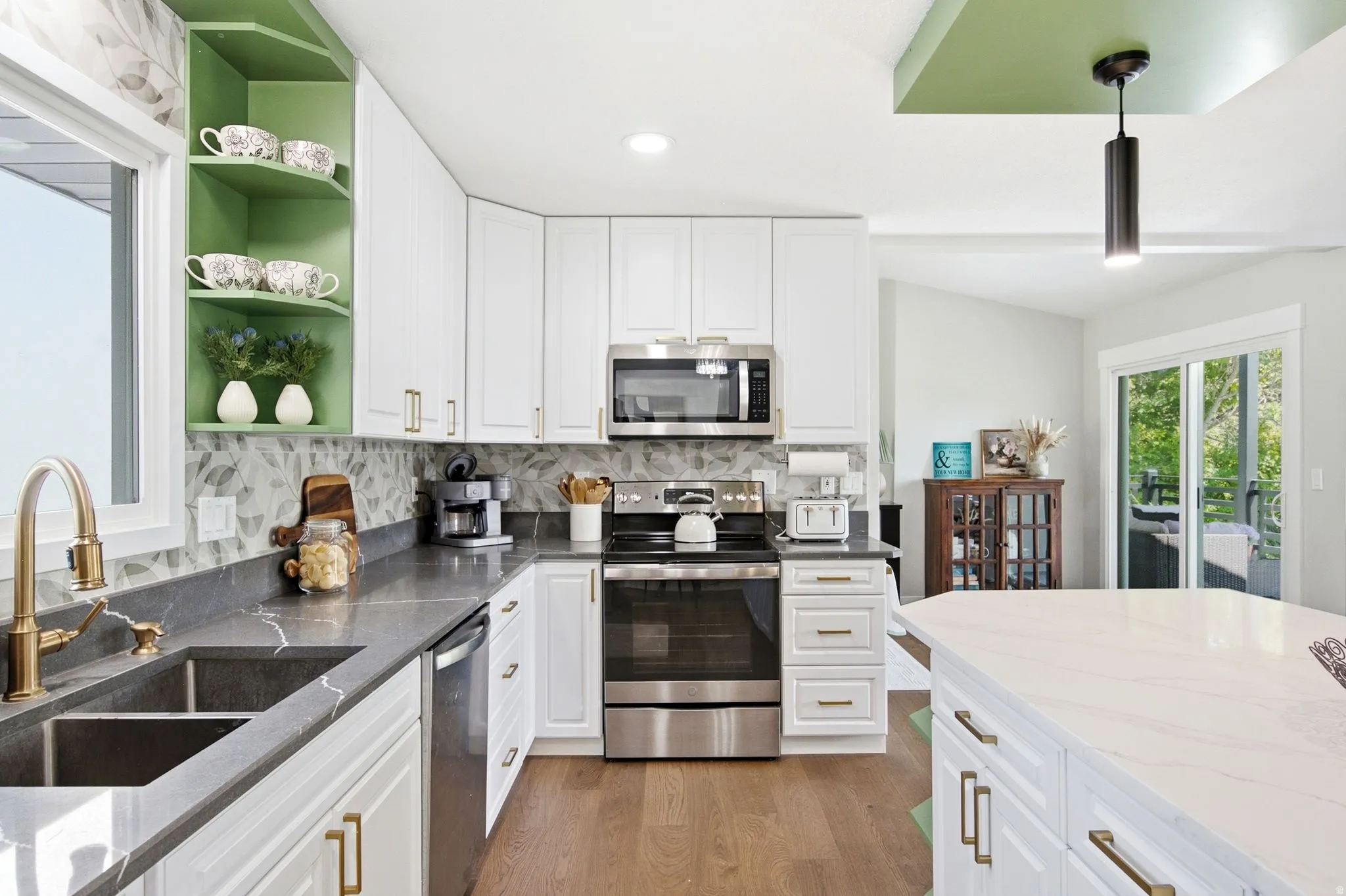 Modern kitchen featuring white cabinetry, stainless steel appliances, a deep basin sink, and a large center island
