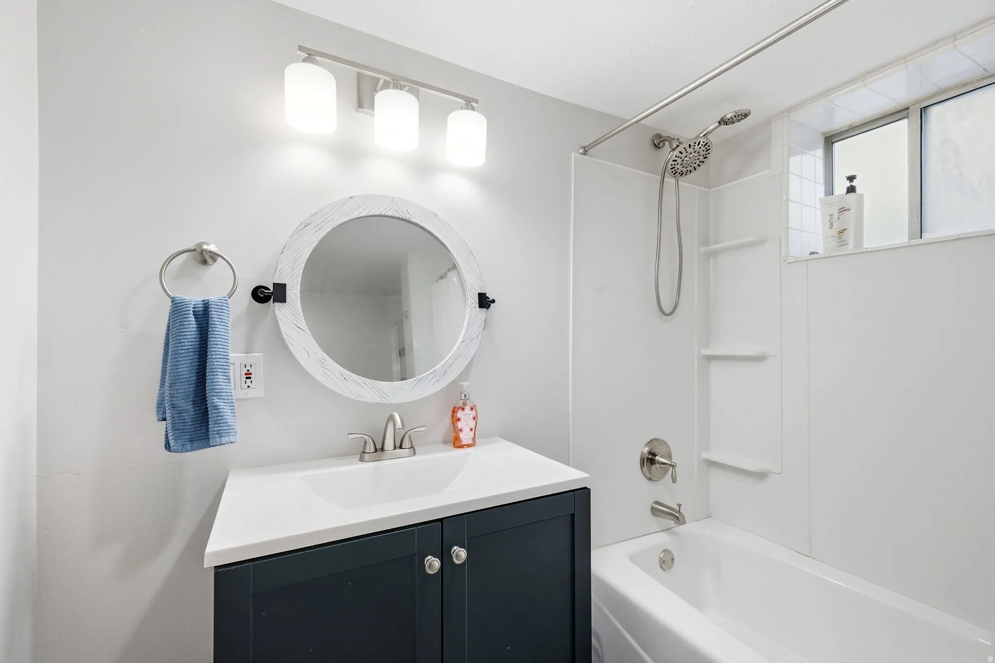 White bathroom with a dark-finish vanity, white countertop, and integrated sink
