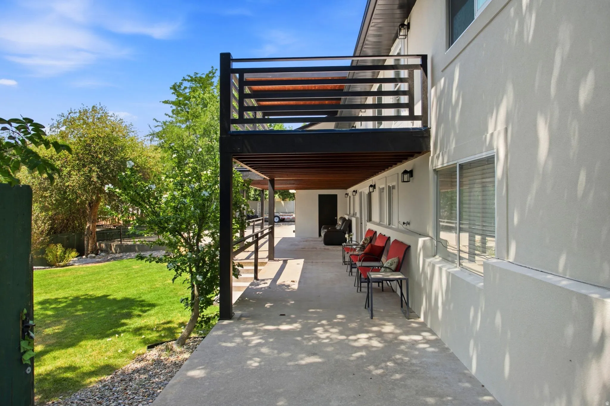 Expansive concrete patio with a wood slat pergola