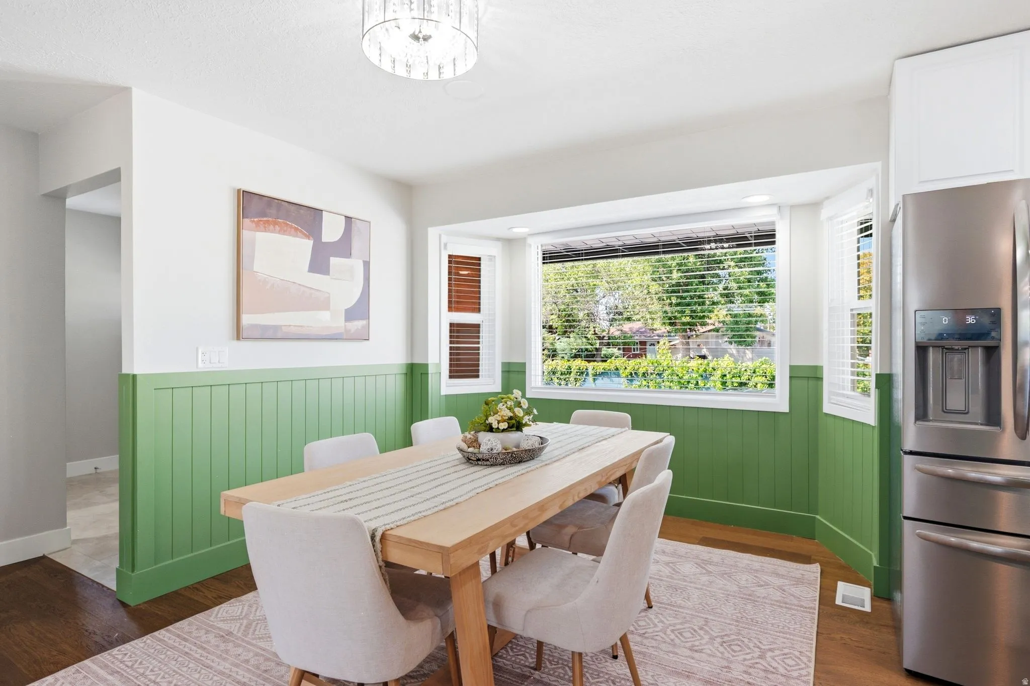 Recessed lighting illuminates the dining area with wood-finish flooring