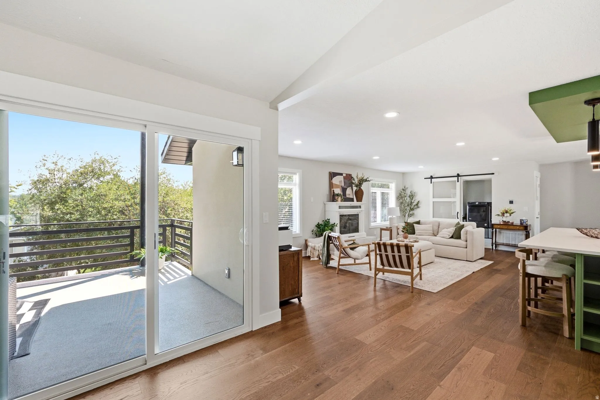 Expansive wood-finish flooring throughout, featuring a living area with a built-in fireplace