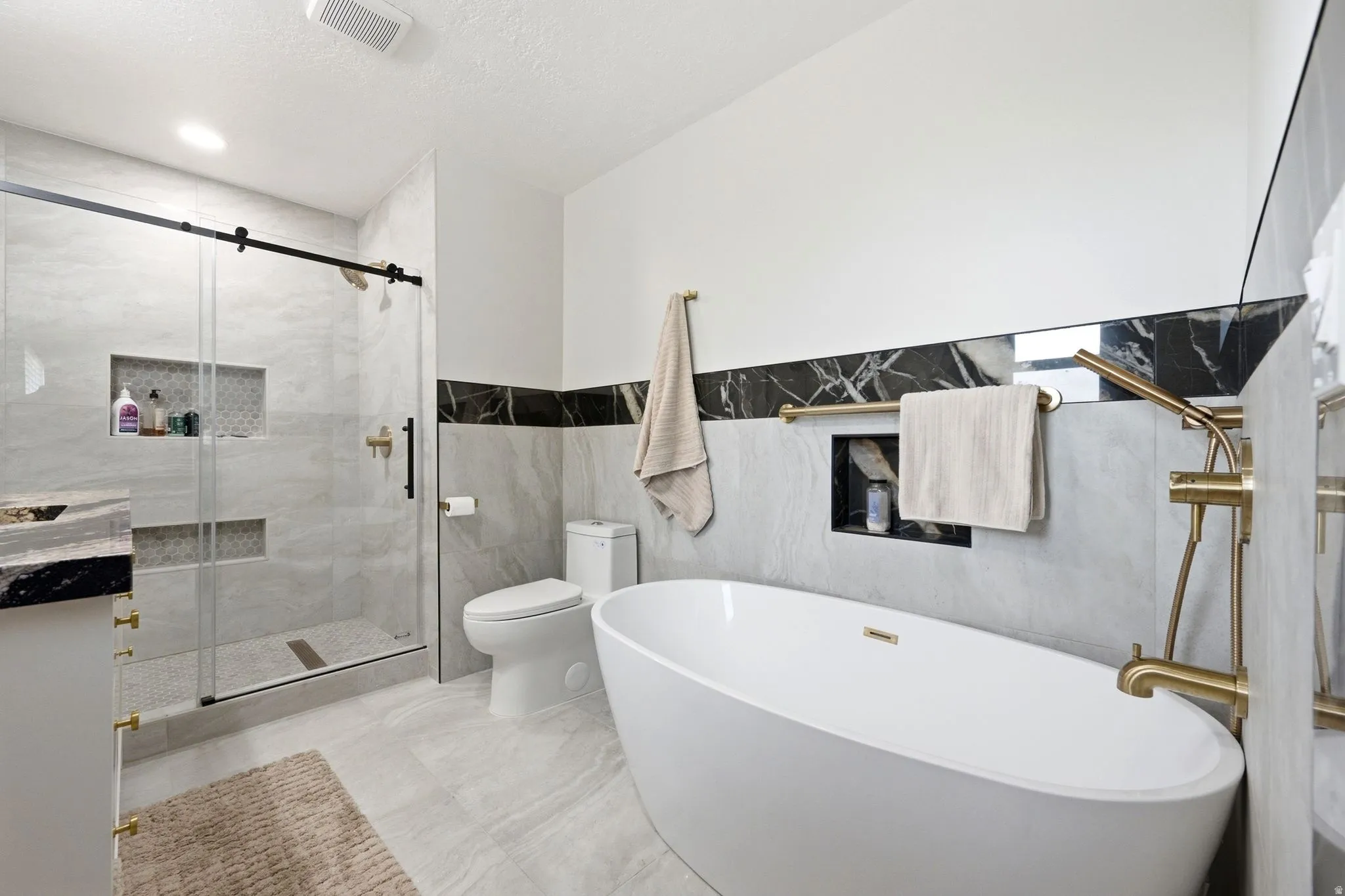 Freestanding soaking tub with a floor-mounted gold-tone faucet