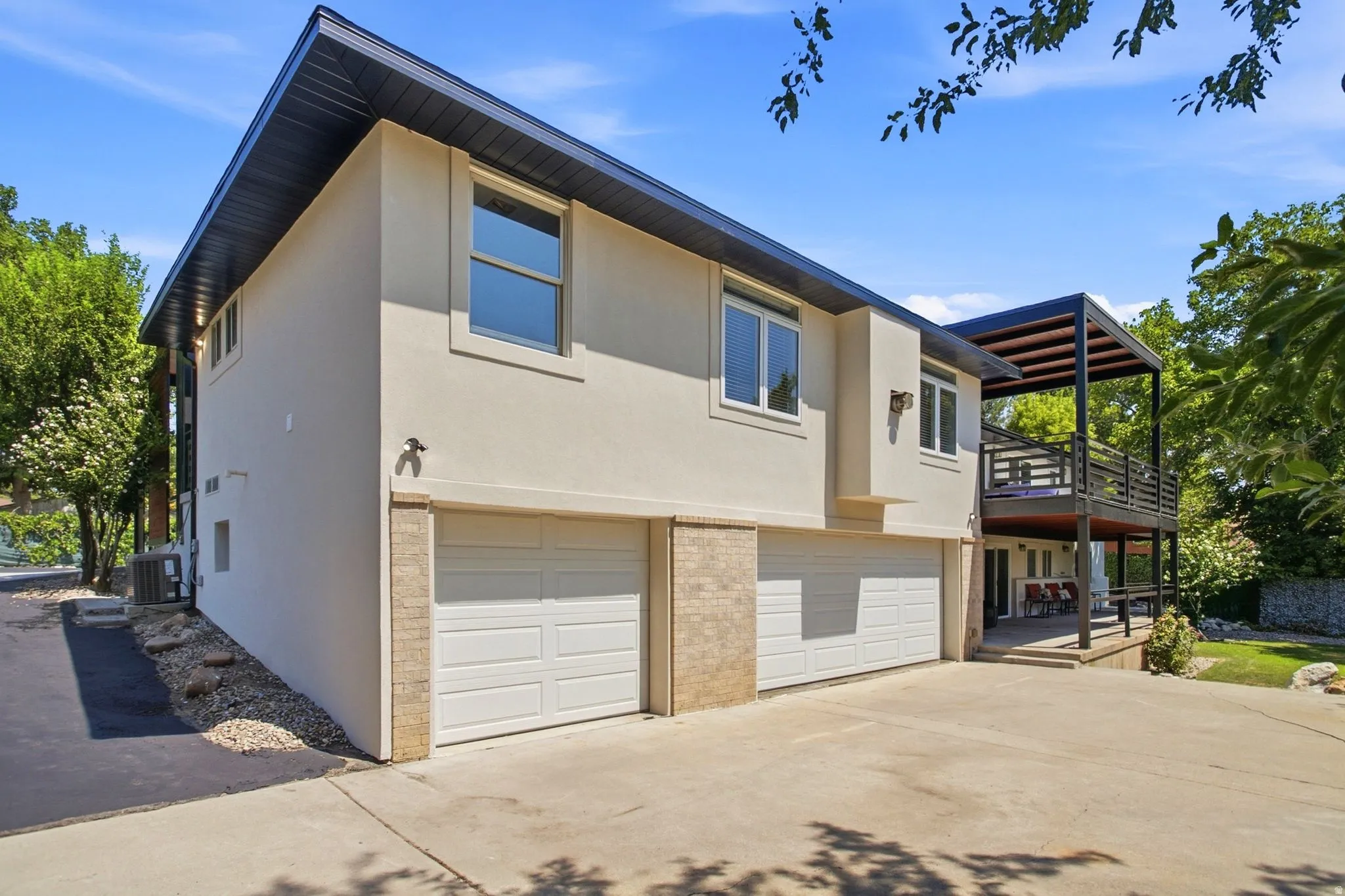 Concrete driveway leading to two white garage doors