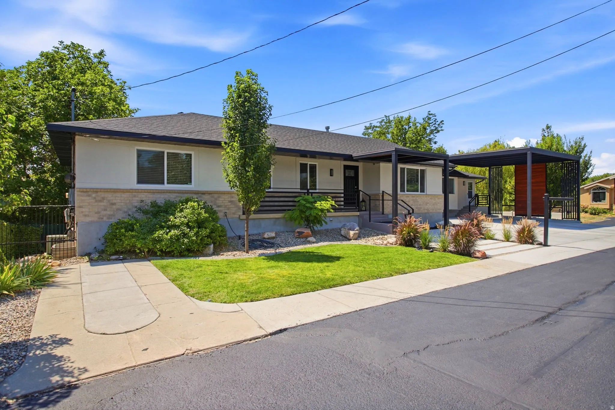 Single-story residence featuring a carport, stucco and brick exterior, and a manicured front lawn