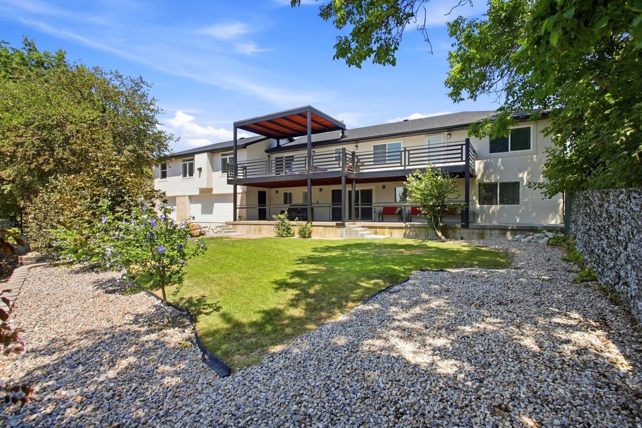 Tiered decking with a modern pergola, a lower-level patio, and a gabion wall