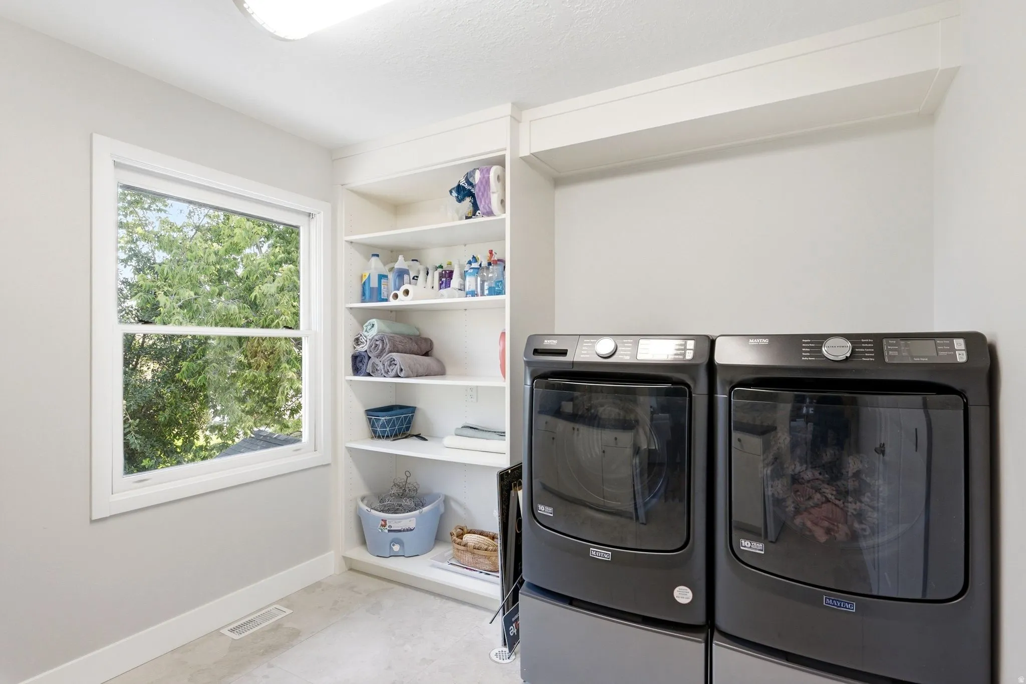 Built-in shelving, white trim window, light gray wall color, flush mount ceiling light