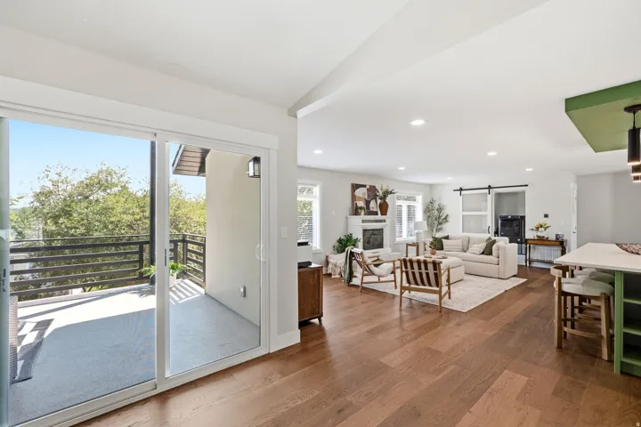 Expansive wood-finish flooring throughout, featuring a living area with a built-in fireplace