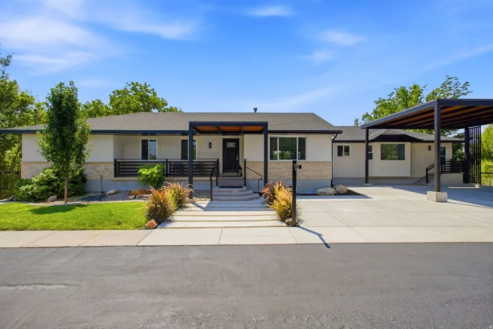 Ranch-style exterior with stone and stucco facade, a covered entry, and an attached carport