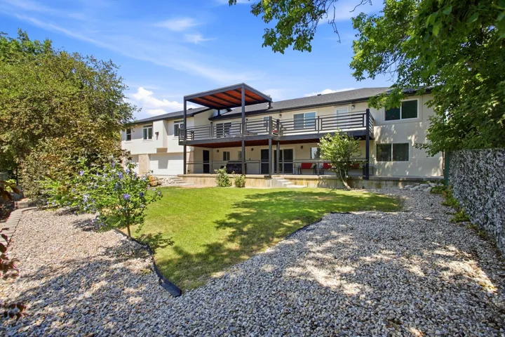 Tiered decking with a modern pergola, a lower-level patio, and a gabion wall
