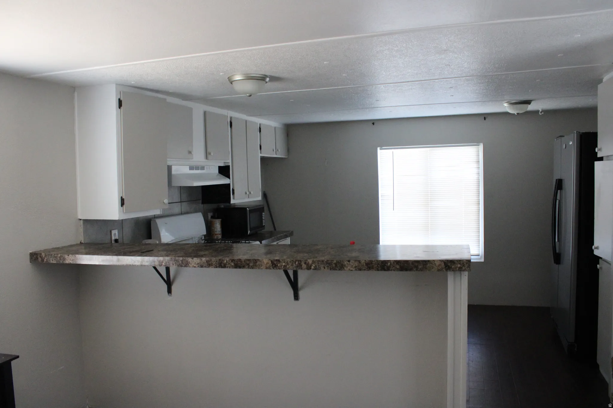 Kitchen featuring light-toned cabinetry, a built-in oven, and a refrigerator