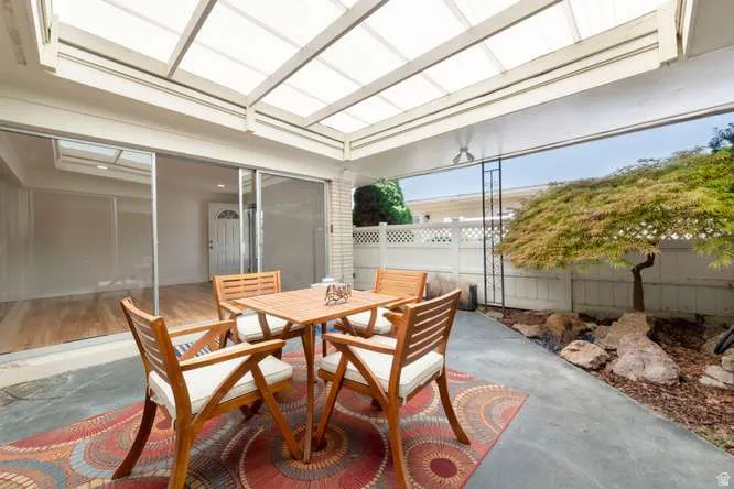 Covered patio with a translucent roof, concrete flooring, and a sliding glass door entry