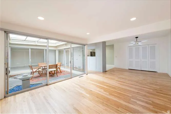 Hardwood flooring, recessed lighting, sliding glass doors, built-in storage, and a modern ceiling fixture