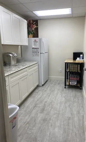 White cabinetry with brushed nickel hardware, granite-style countertops, wood-finish flooring, and recessed ceiling lighting