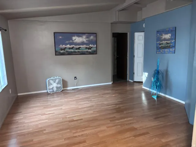 Wood-finish flooring throughout, light blue accent wall, and white trim
