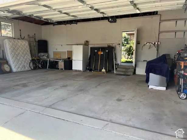 Attached garage featuring concrete flooring and a pedestrian door