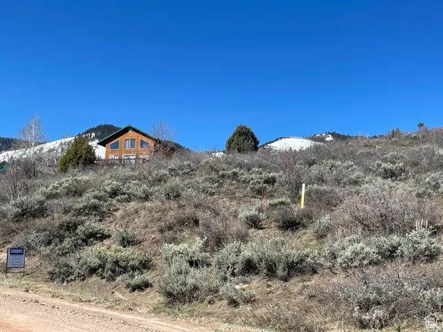 Mountain-side residence with A-frame architectural elements, expansive deck, and large windows