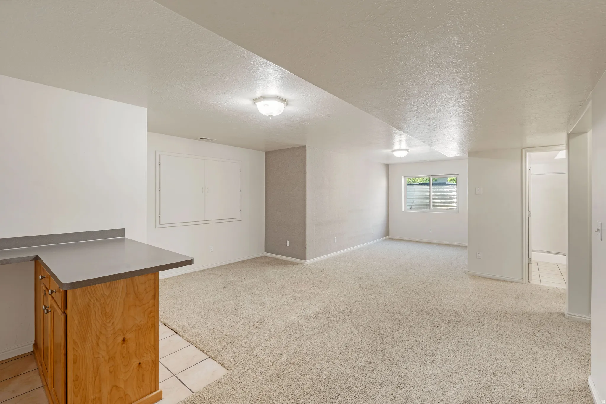 Built-in cabinetry with a countertop, recessed window, and wall-mounted light fixtures