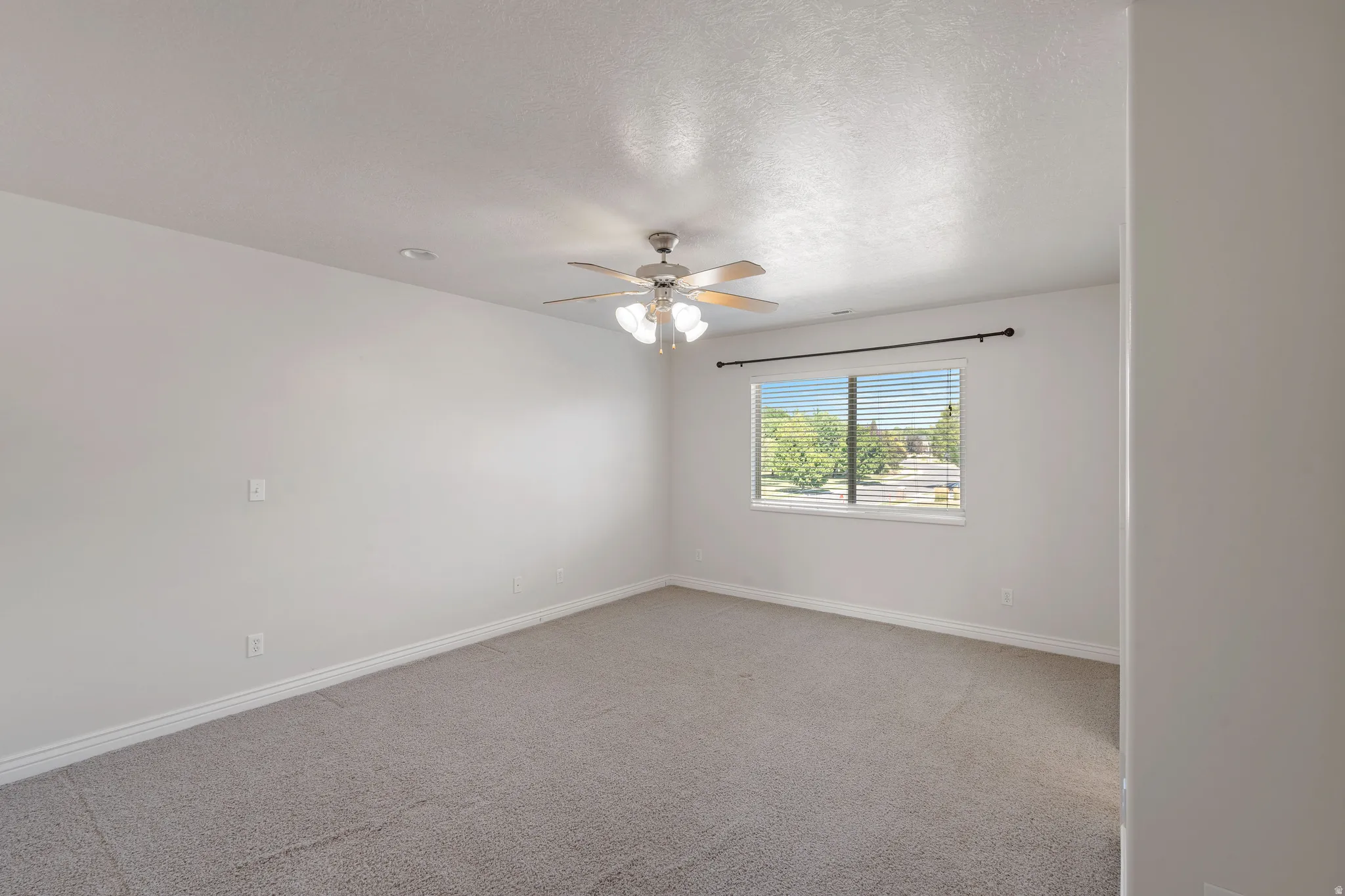 Carpeted flooring, white painted walls, window with blinds, ceiling fan with light fixture, and recessed lighting