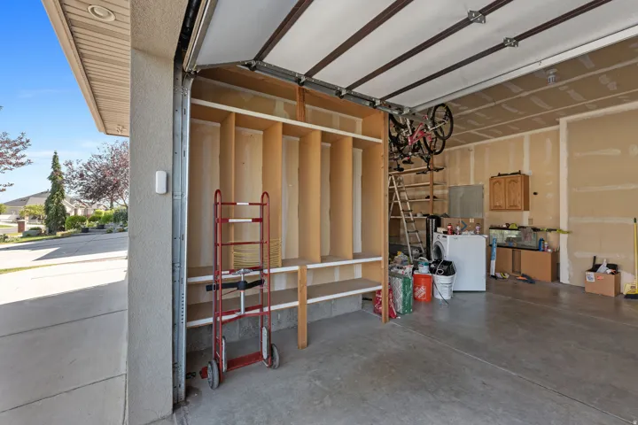 Garage with concrete flooring, built-in shelving, and overhead storage