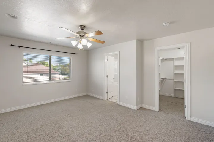 Recessed lighting, ceiling fan with light fixture, window with blinds, carpeted flooring, and built-in closet shelving